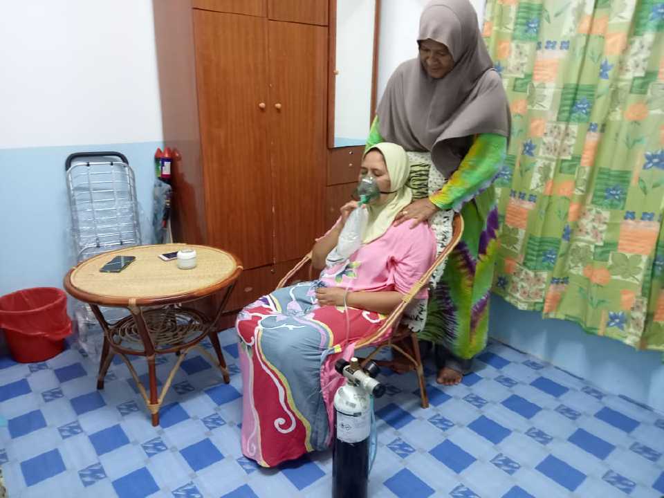 Rozyna Ahmad, 47, menerima bantuan oksigen daripada bomba ekoran sesak nafas dalam kejadian pencemaran kimia di Kampung Baru Sri Aman, Seelong, malam tadi. - Foto ihsan penduduk